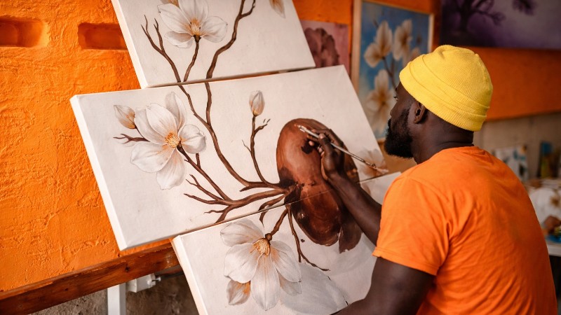 Artist painting magnolia triptych in studio